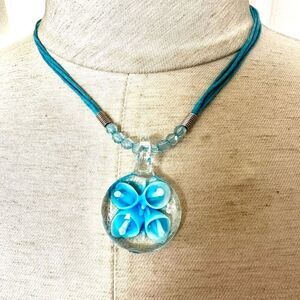 Blue flower glass pendant necklace on blue cord